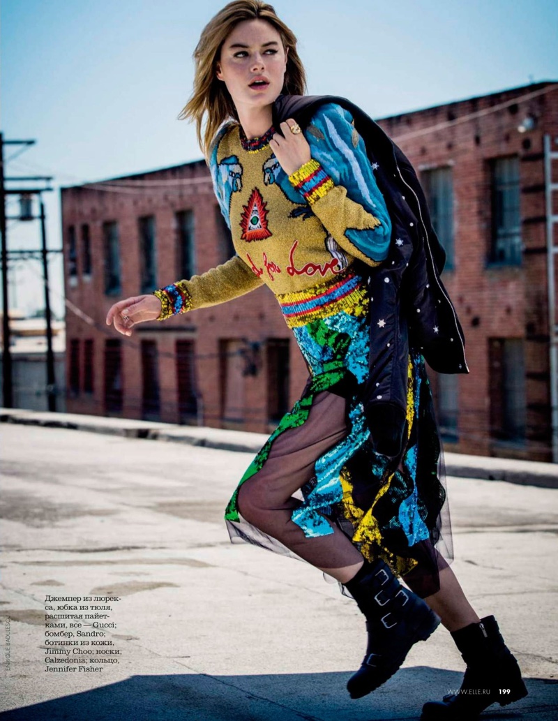 A girl on the run, Camille Rowe wears Gucci sweater and skirt with Sandro jacket and Jimmy Choo boots