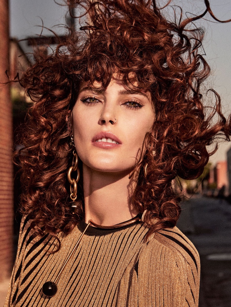 Wearing a curly hairstyle, Catherine McNeil poses in Sonia Rykiel dress with Marni earrings