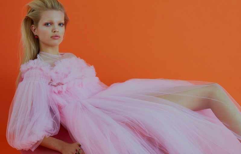 Lounging on a couch, Daphne Groeneveld wears fluffy pink gown