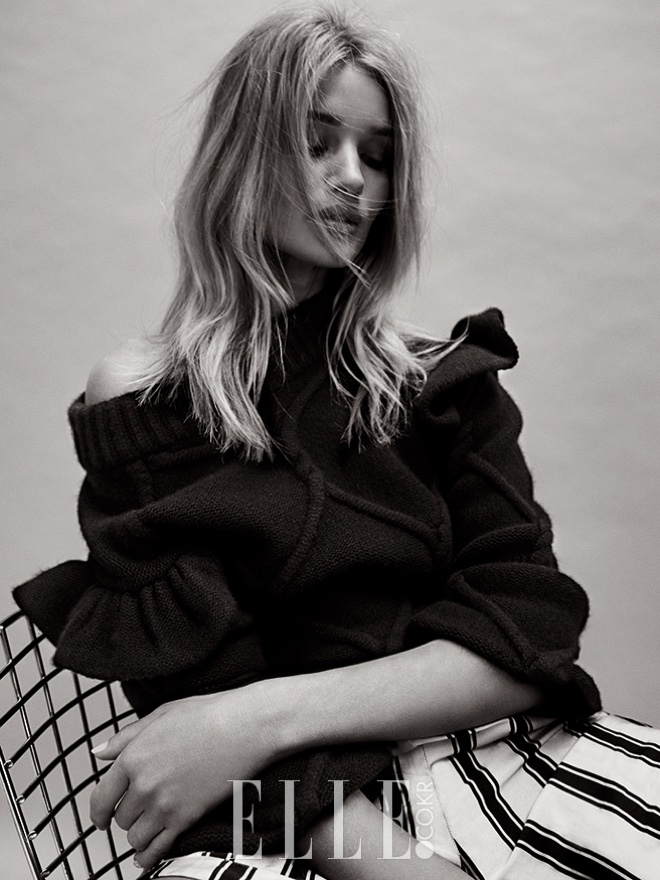 Photographed in black and white, Rosie Huntington-Whiteley wears Burberry sweater and trousers