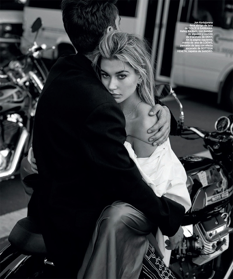 Hailey Baldwin poses on the back of a motorbike wearing a DKNY bomber jacket and dress