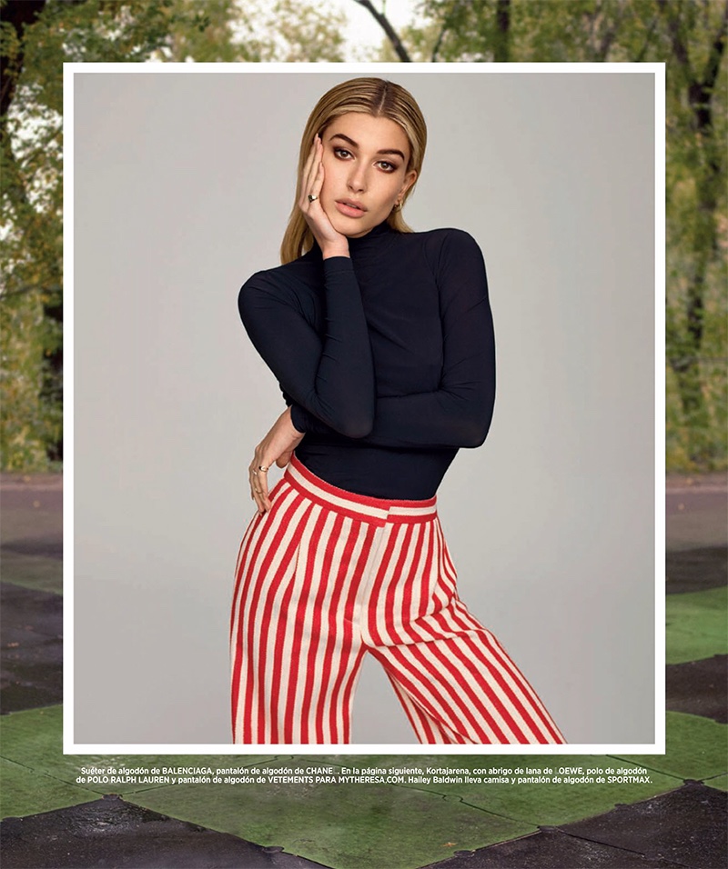 Hailey Baldwin poses in Balenciaga sweater and Chanel striped pants