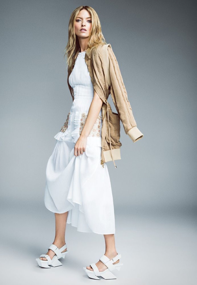 Striking a pose, Martha Hunt wears tan jacket with white embellished dress and platform sandals