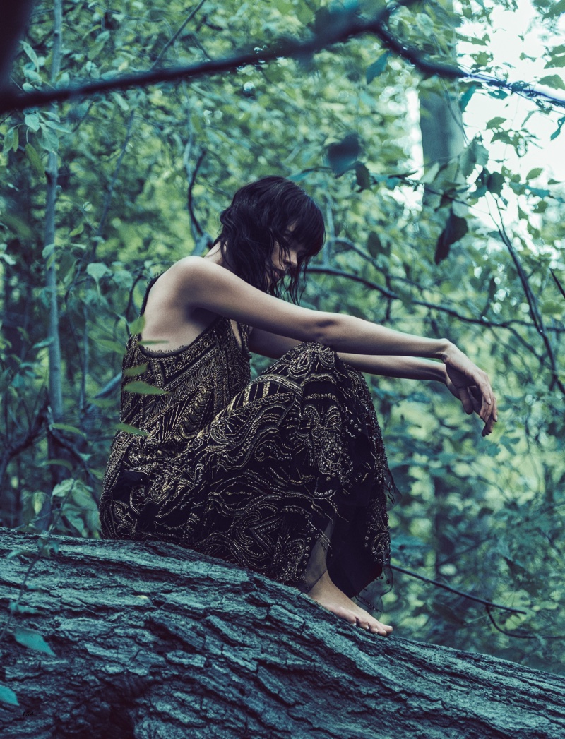 Posing barefoot, Meghan Collison models Roberto Cavalli embroidered dress