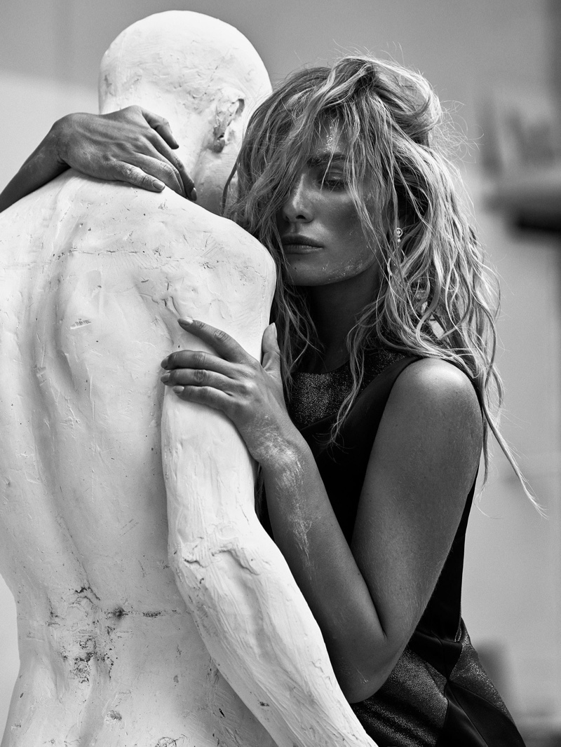 Model Tatana Kucharova poses next to a white statue in this black and white shot
