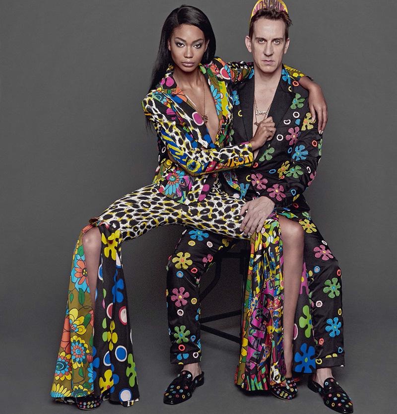 Model Chanel Iman and designer Jeremy Scott pose in pantsuits from Moschino's resort 2017 collection