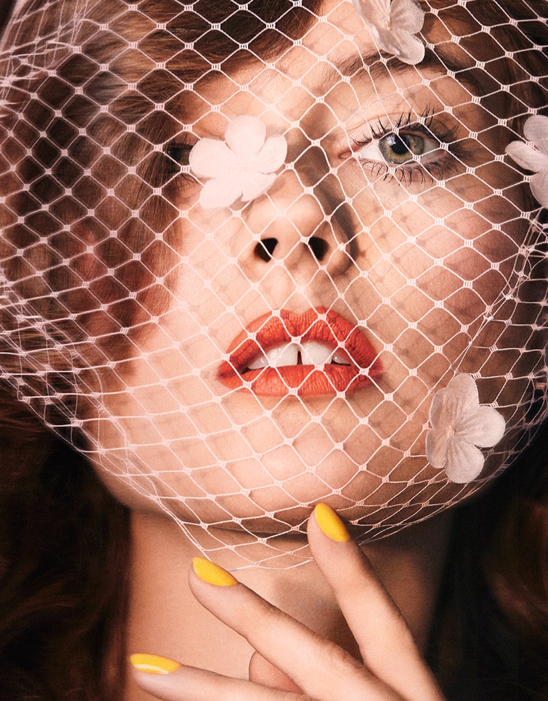 The model shows off a yellow manicure with Jennifer Behr veil