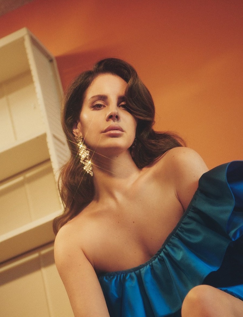 Flaunting some shoulder, Lana Del Rey models Gucci silk asymmetrical dress with Saint Laurent crystal earrings