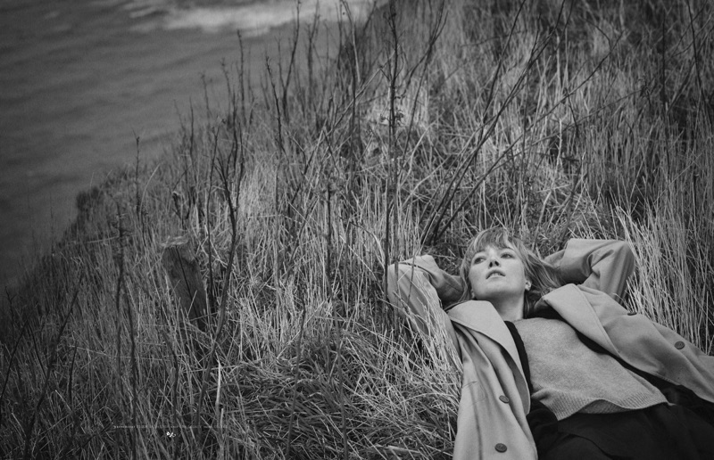 Posing outdoors, Lou Schoof models Tiger of Sweden trench coat, Our Legacy sweater and Celine skirt