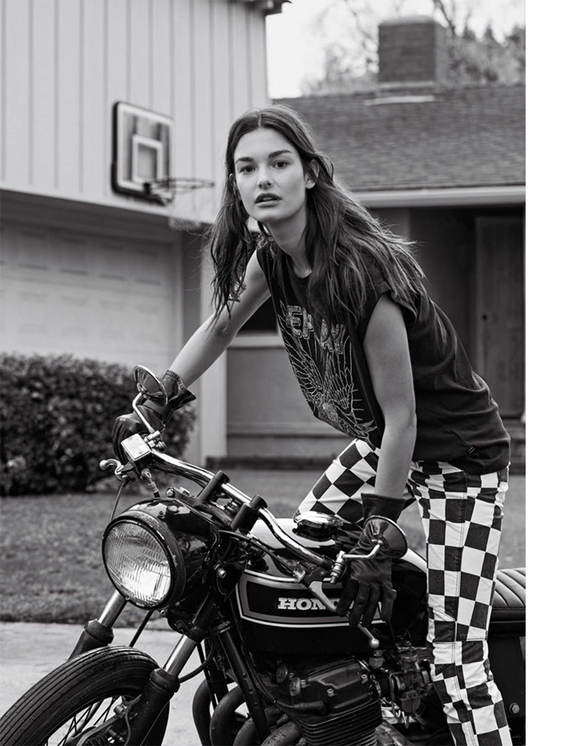 Sitting on a motorcycle, Ophelie Guillermand models Replay t-shirt and G-Star Raw checkered pants