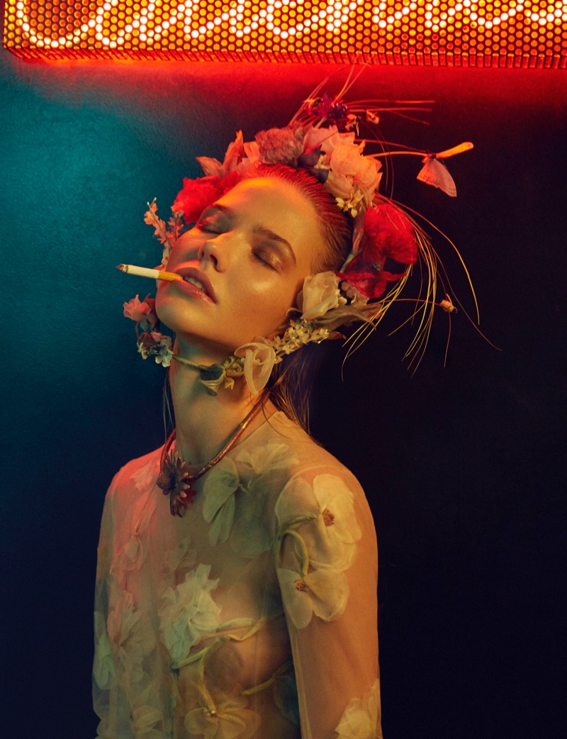 Posing with a cigarette, Sasha Luss models flower crown and floral embellished dress