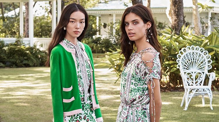 Fei Fei Sun wears Tory Burch Kendra Cardigan, Kia Bow Blouse, Maine Skirt, Embellished Small Bermuda Bag, Pearl Drop Earring and Ruffle Sneakers. Sara Sampaio wears Tory Burch Asilomar Dress, Tatiana Slide and Fish Mismatched Earring.