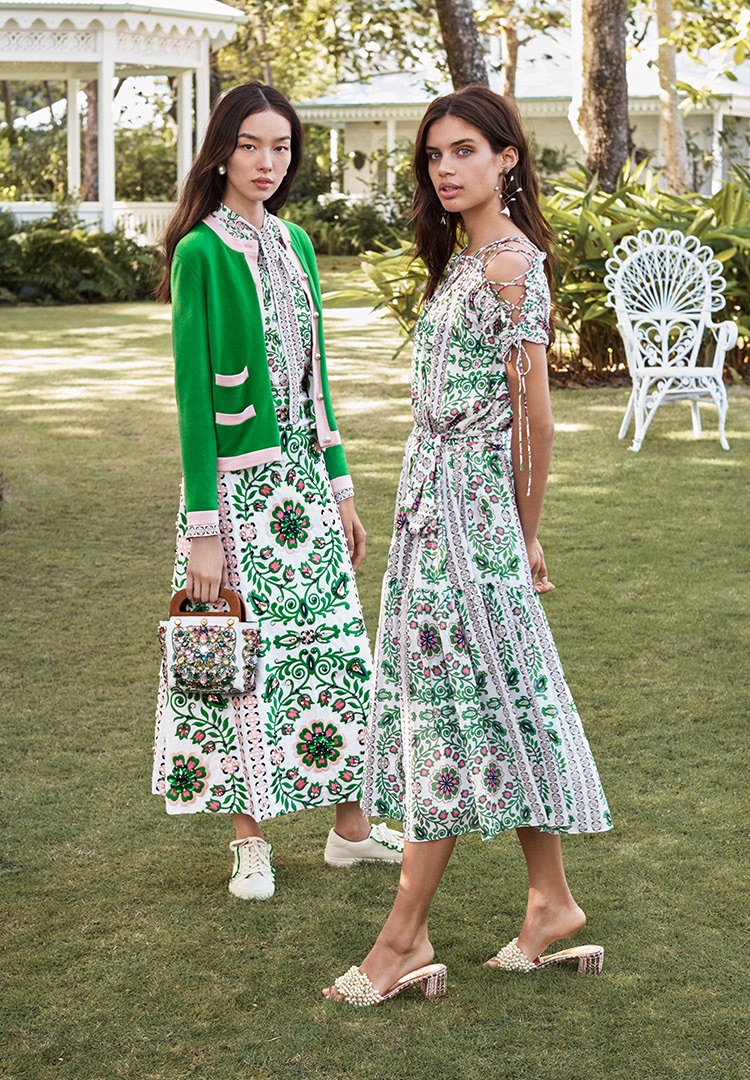 Fei Fei Sun wears Tory Burch Kendra Cardigan, Kia Bow Blouse, Maine Skirt, Embellished Small Bermuda Bag, Pearl Drop Earring and Ruffle Sneakers. Sara Sampaio wears Tory Burch Asilomar Dress, Tatiana Slide and Fish Mismatched Earring.