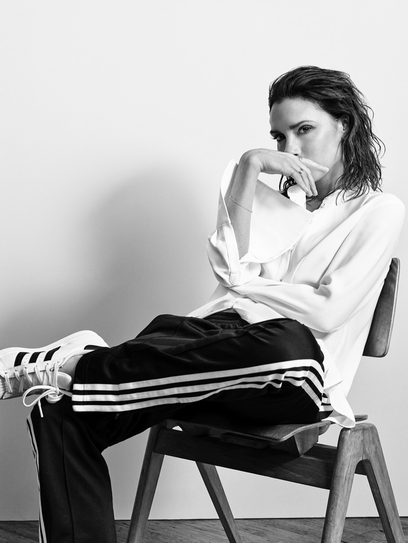 Victoria Beckham poses in button-up blouse, adidas track pants and sneakers