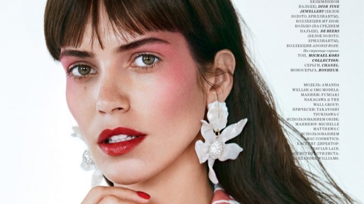 Wearing a Miu Miu coat, Amanda Wellsh shows off a vibrant red shade of lipstick