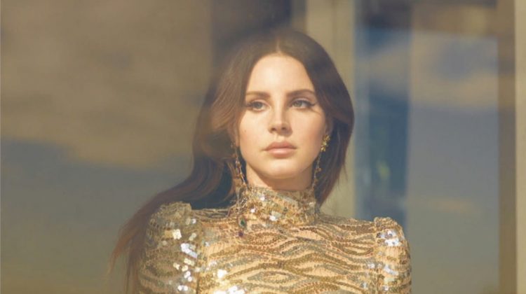 Singer Lana Del Rey models a gold Marc Jacobs sequined dress with Rodarte earrings