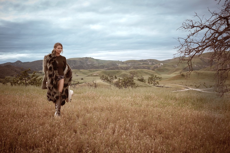 Chrissy Teigen poses outdoors in fur and knitwear