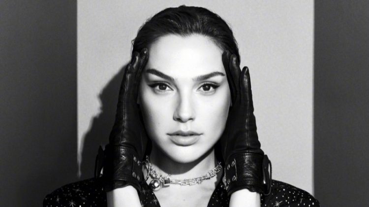 Photographed in black and white, Gal Gadot wears leather gloves and star print dress