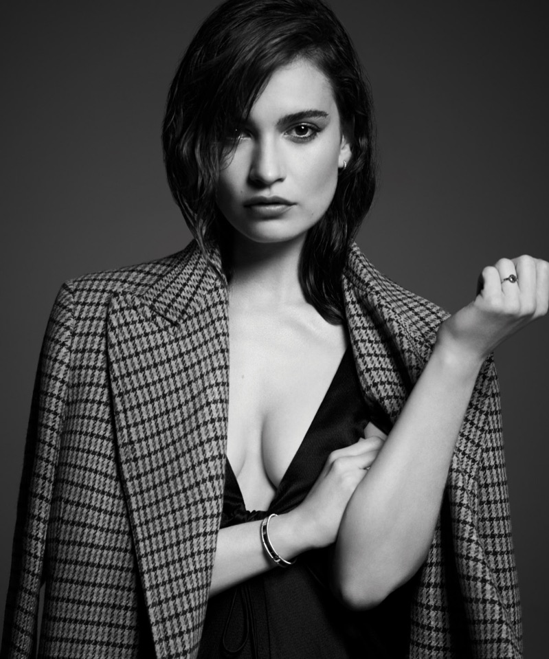 Lily James poses in Joseph coat, T by Alexander Wang dress and De Beers earrings