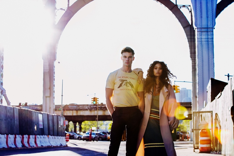 James wears Bravado Rolling Stones Band Tee, REISS Hollidge Slim Fit Tailored Trousers. Ziayla wears stylist’s own Hoop Earrings, Assorted Rings (all) Nissa Jewelry, Tibi Drape Twill Trench Coat and Use Unused Striped Dress