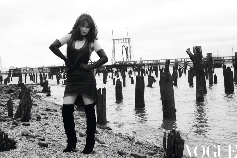 Actress Emilia Clarke strikes a pose in a black dress and knee-high boots