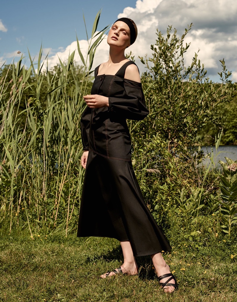 Model Guinevere van Seenus poses in Ellery cold-shoulder dress and The Row leather sandals