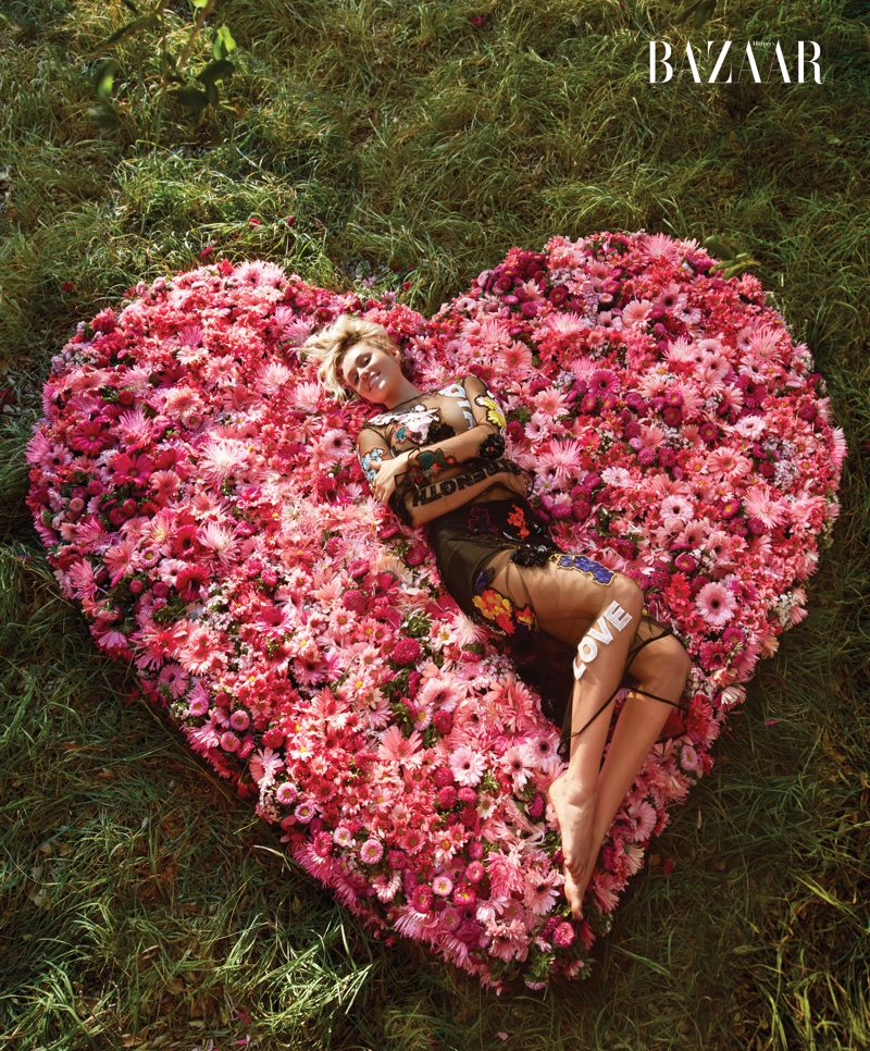 Posing on a bed of flowers, Miley Cyrus wears Versace top and skirt
