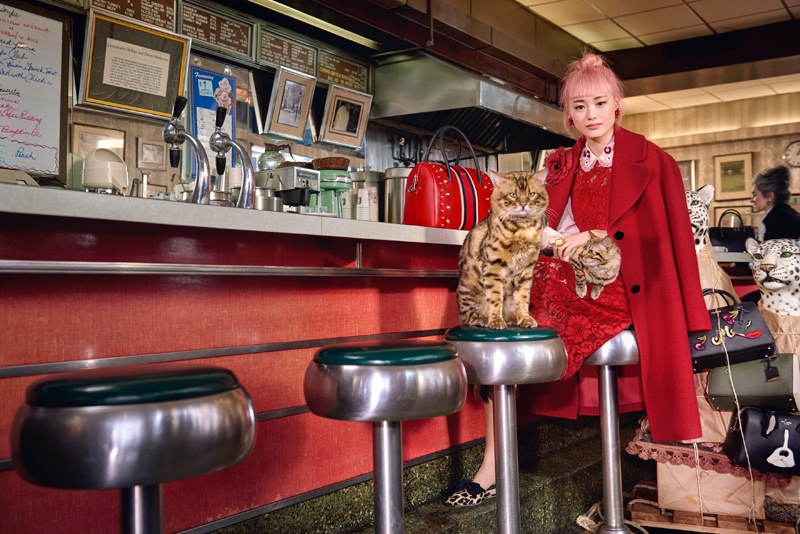 Fernanda Ly poses in a New York diner wearing a red jacket for Kate Spade's fall-winter 2017 ad campaign