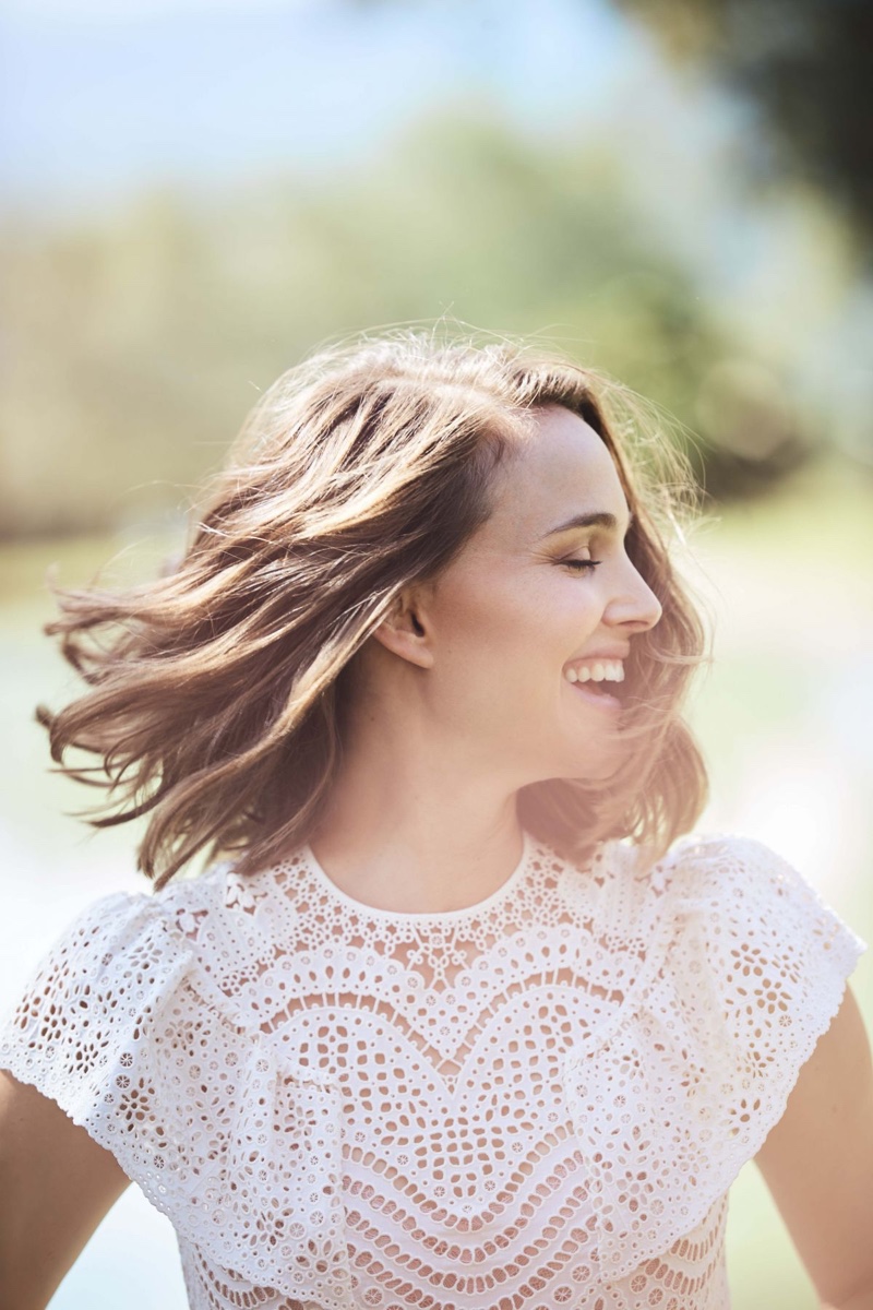 All smiles, Natalie Portman wears a white dress