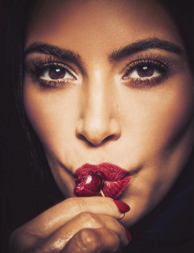 Kim Kardashian poses in bold scarlet lipstick with matching manicure