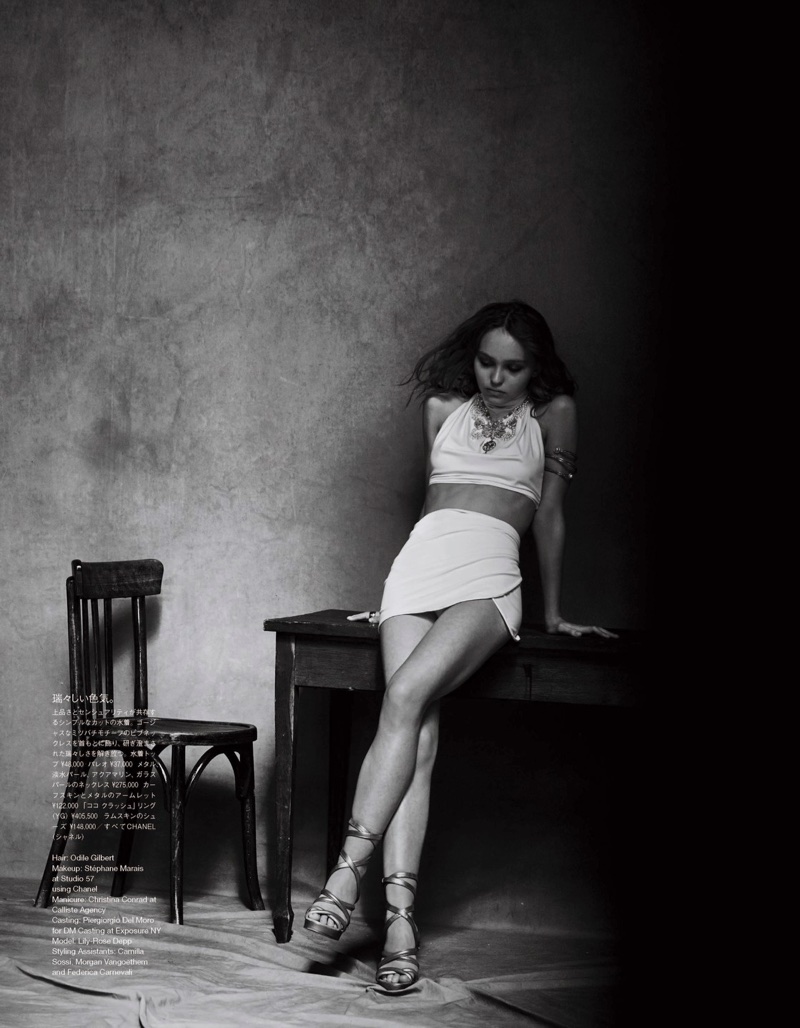Photographed in black and white, Lily-Rose Depp wears cropped top, skirt and sandals from Chanel