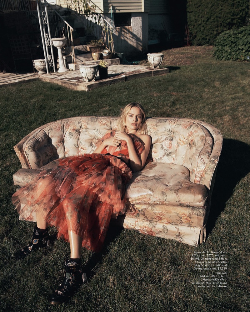 Posing on a sofa, Margot Robbie wears Alexander McQueen dress, belt and boots