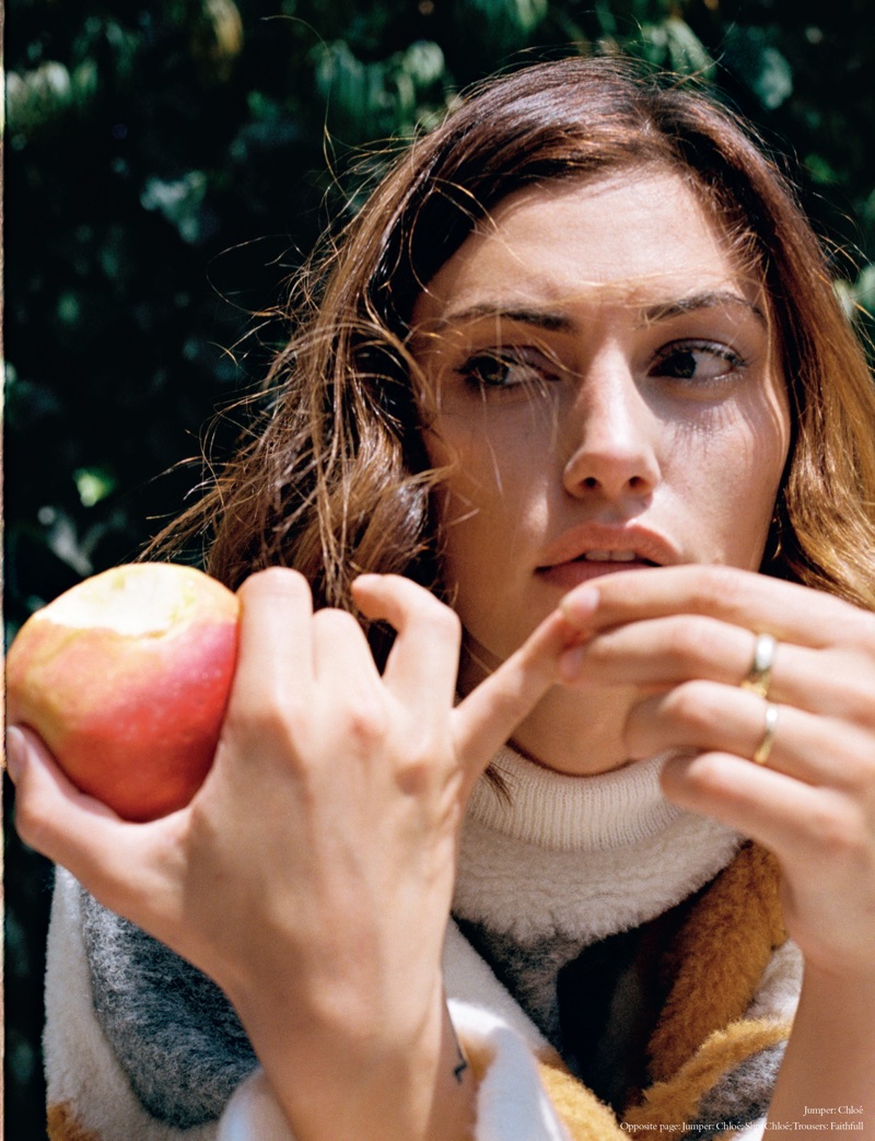 Posing with an apple, Phoebe Tonkin wears Chloe sweater