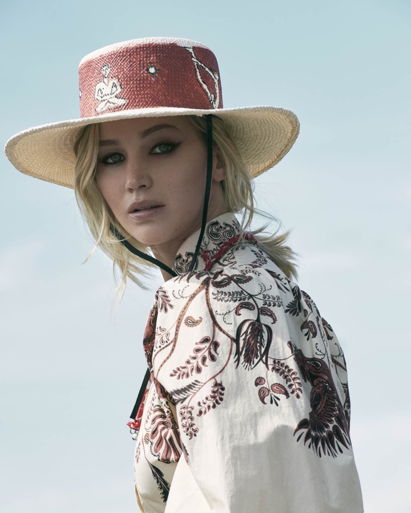 Actress Jennifer Lawrence wears wide-brimmed hat and printed dress from Dior