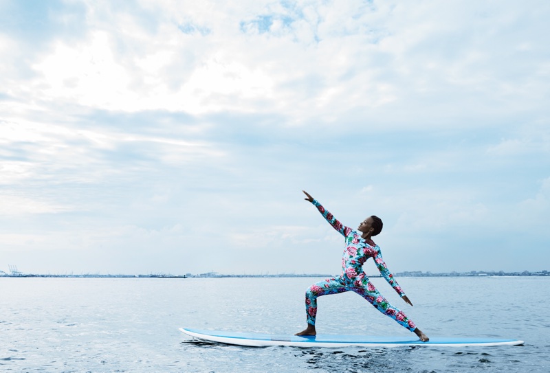 Actress Lupita Nyong’o poses on a paddleboard wearing a Dolce & Gabbana jumpsuit