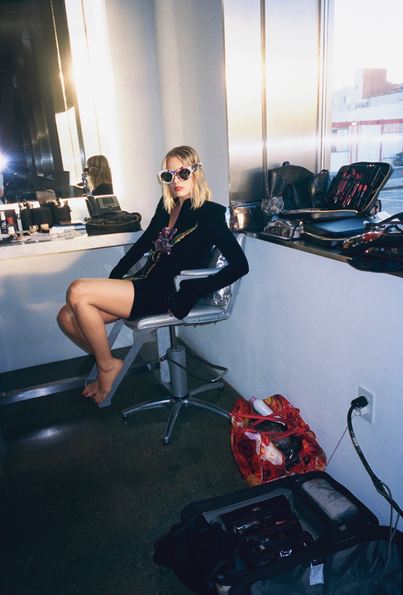 Shot backstage, Margot Robbie wears Saint Laurent dress and Moschino sunglasses