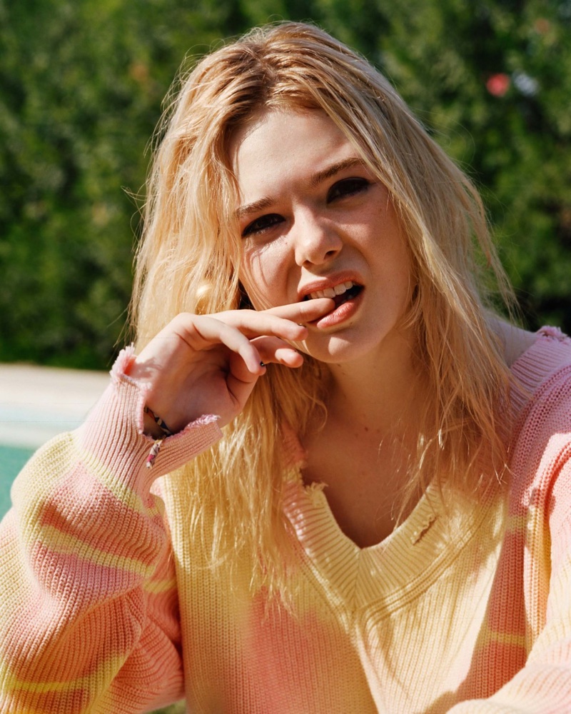 Making a face, Elle Fanning poses in pink sweater