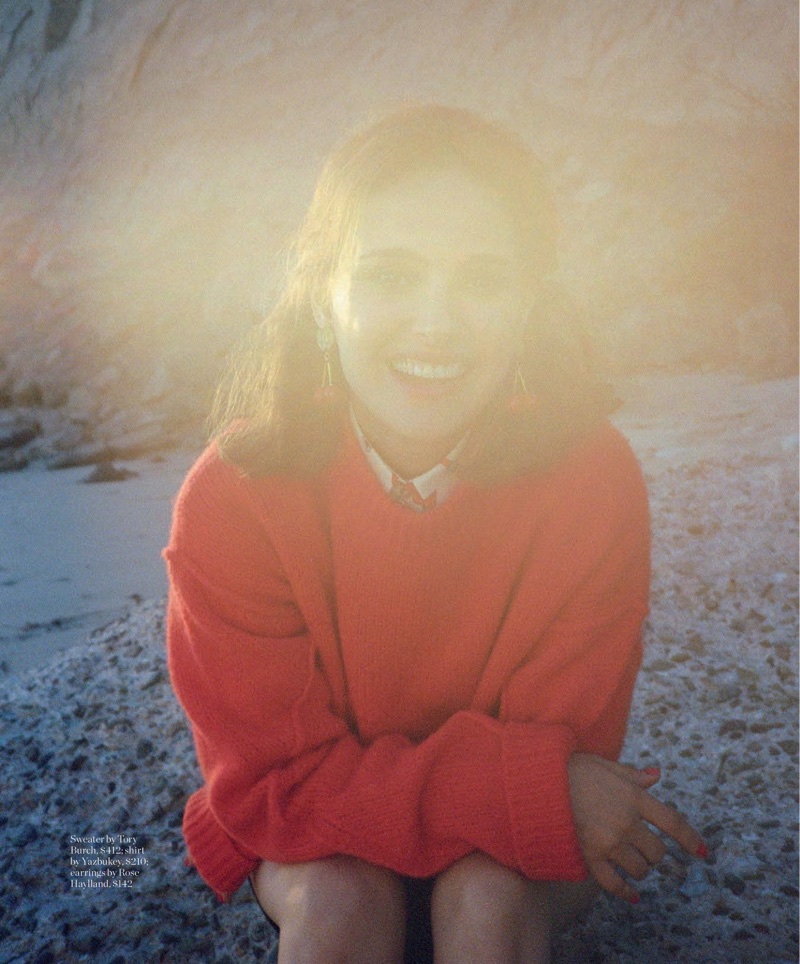 Flashing a smile, Natalie Portman poses in red Tory Burch sweater and Rose Haylland earrings