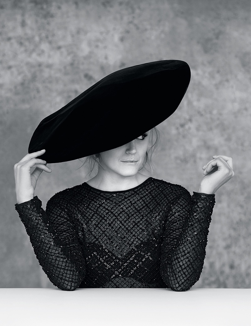 Actress Taylor Schilling poses in Saint Laurent velvet flat hat and embroidered knit pullover