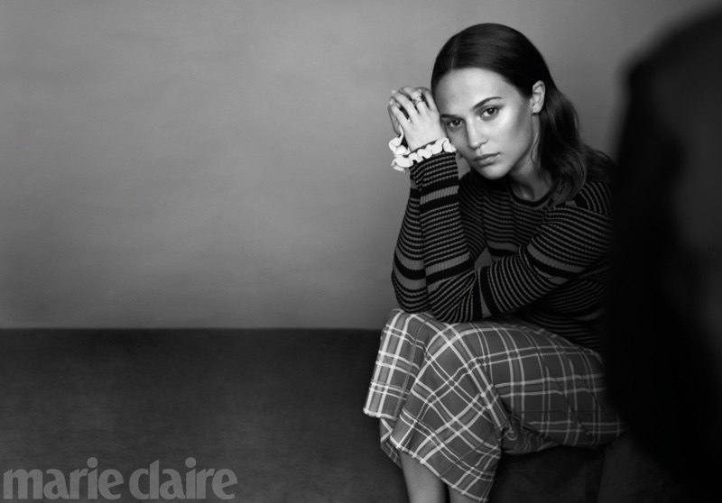 Photographed in black and white, Alicia Vikander striped blouse and checkered skirt