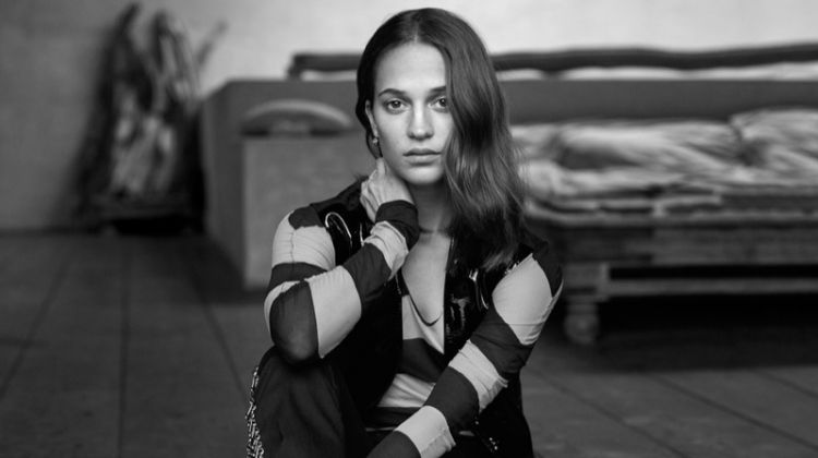 Alicia Vikander poses in Louis Vuitton vest, top, pants and earrings