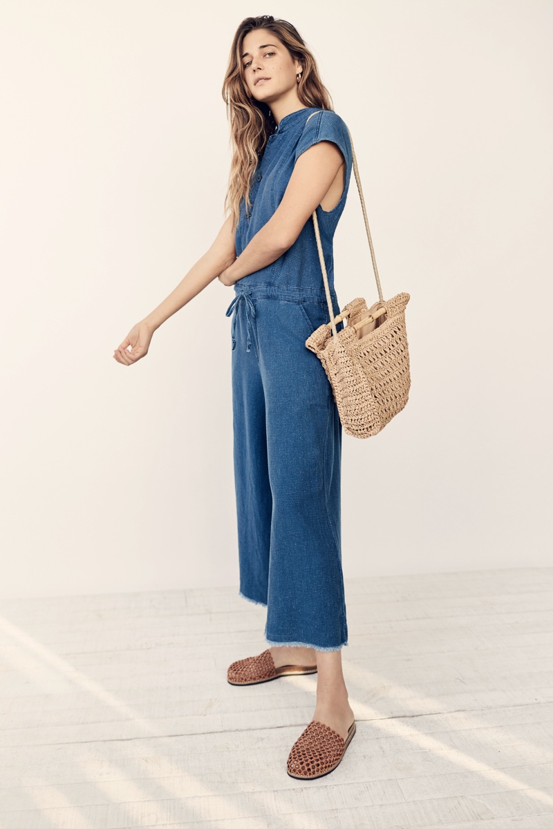 Ally Walsh wears NSF Carmina Jumpsuit and Free People Dreamland Straw Clutch