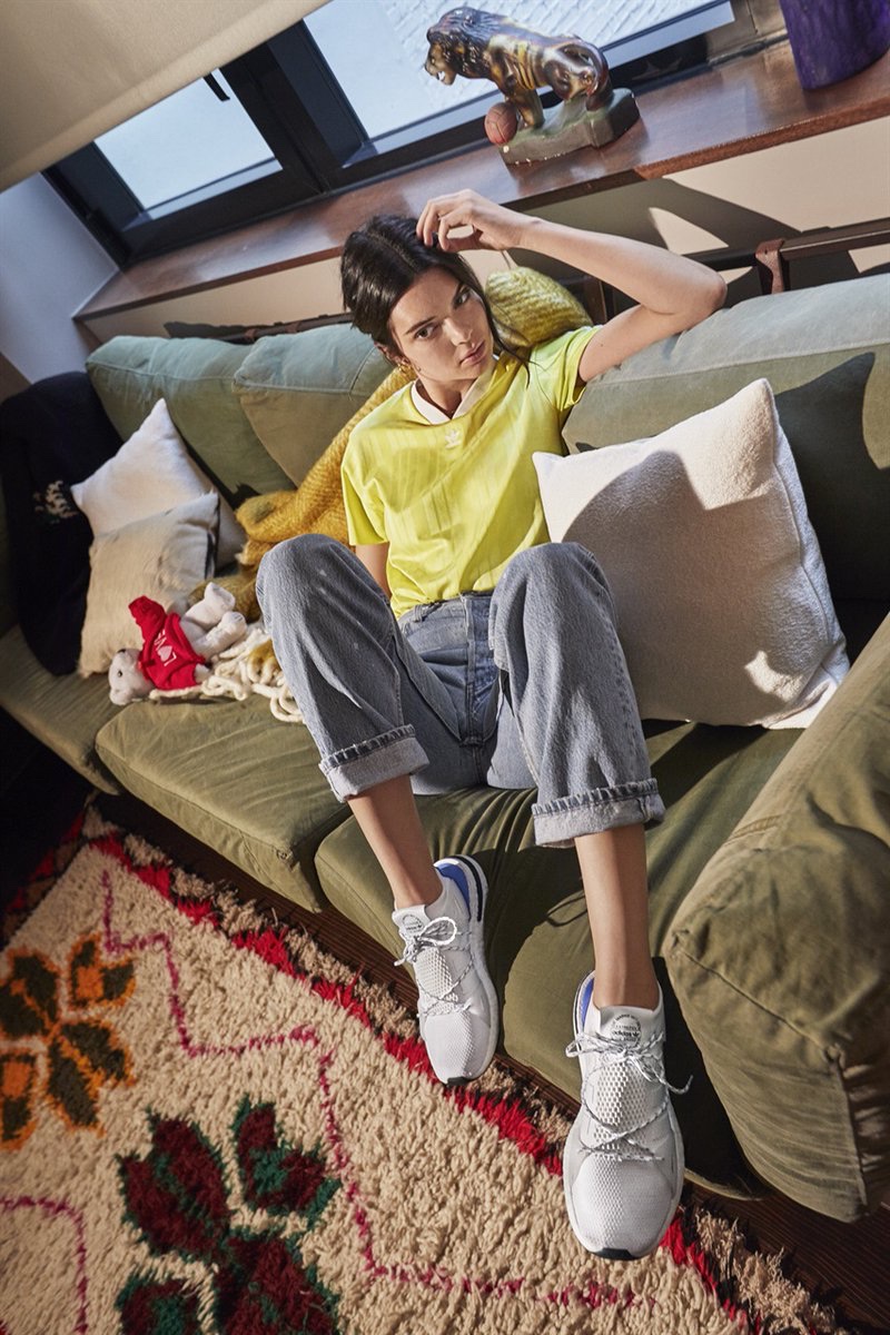 Posing on a couch, Kendall Jenner wears adidas Originals Arkyn sneaker