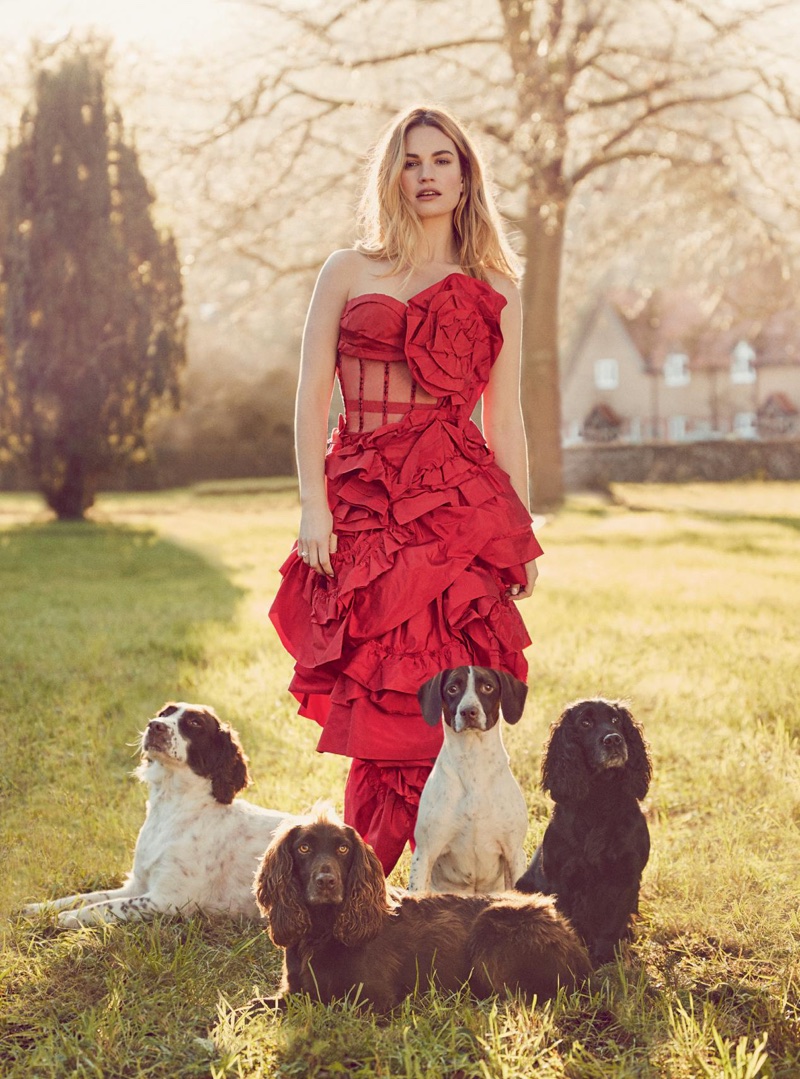 Posing with dogs, Lily James wears red Alexander McQueen corset dress and skirt