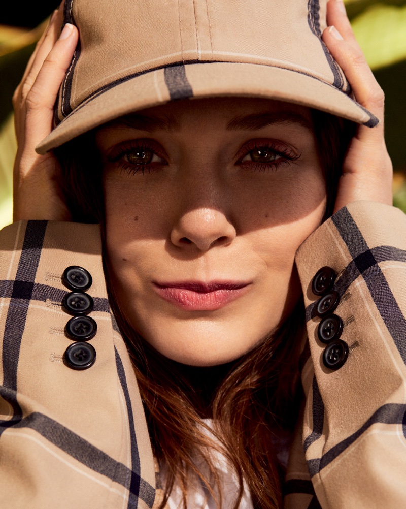 Ready for her closeup, Elizabeth Olsen poses in checkered cap and jacket