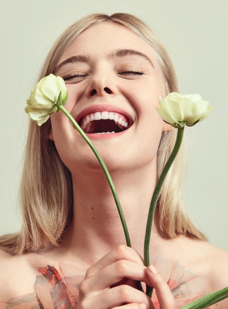 Posing with flowers, Elle Fanning flashes a smile