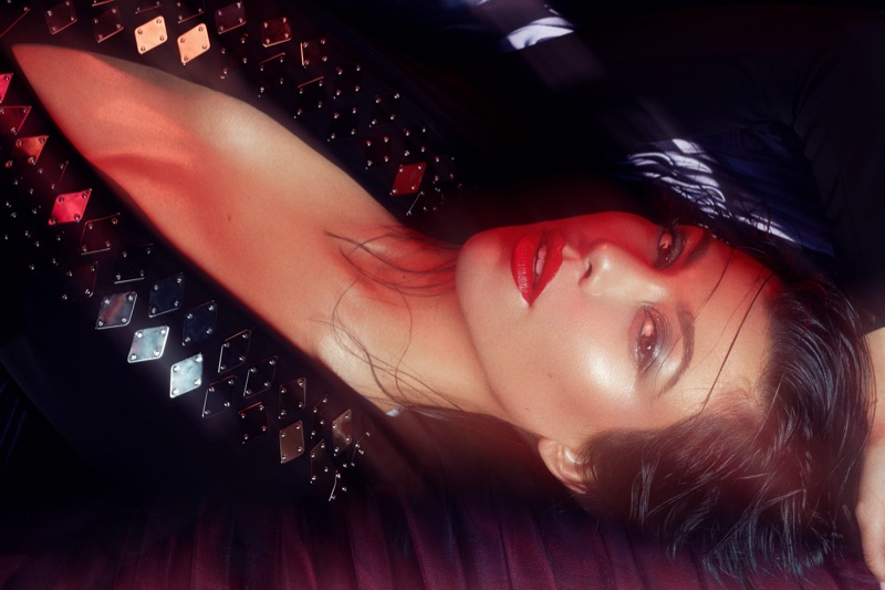 Wearing red lipstick, Kourtney Kardashian poses in Mugler bodysuit