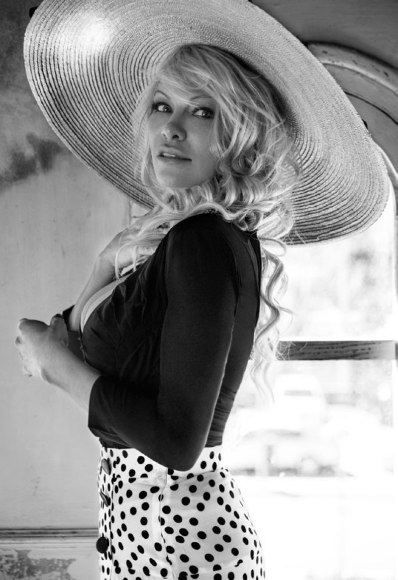 Actress Pamela Anderson poses in straw hat, cardigan and skirt