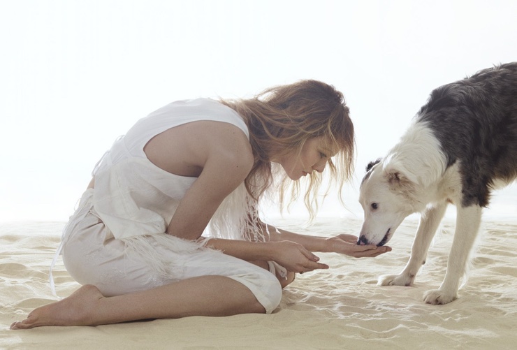 Dressed in white, Vanessa Paradis poses with a dog in this shot