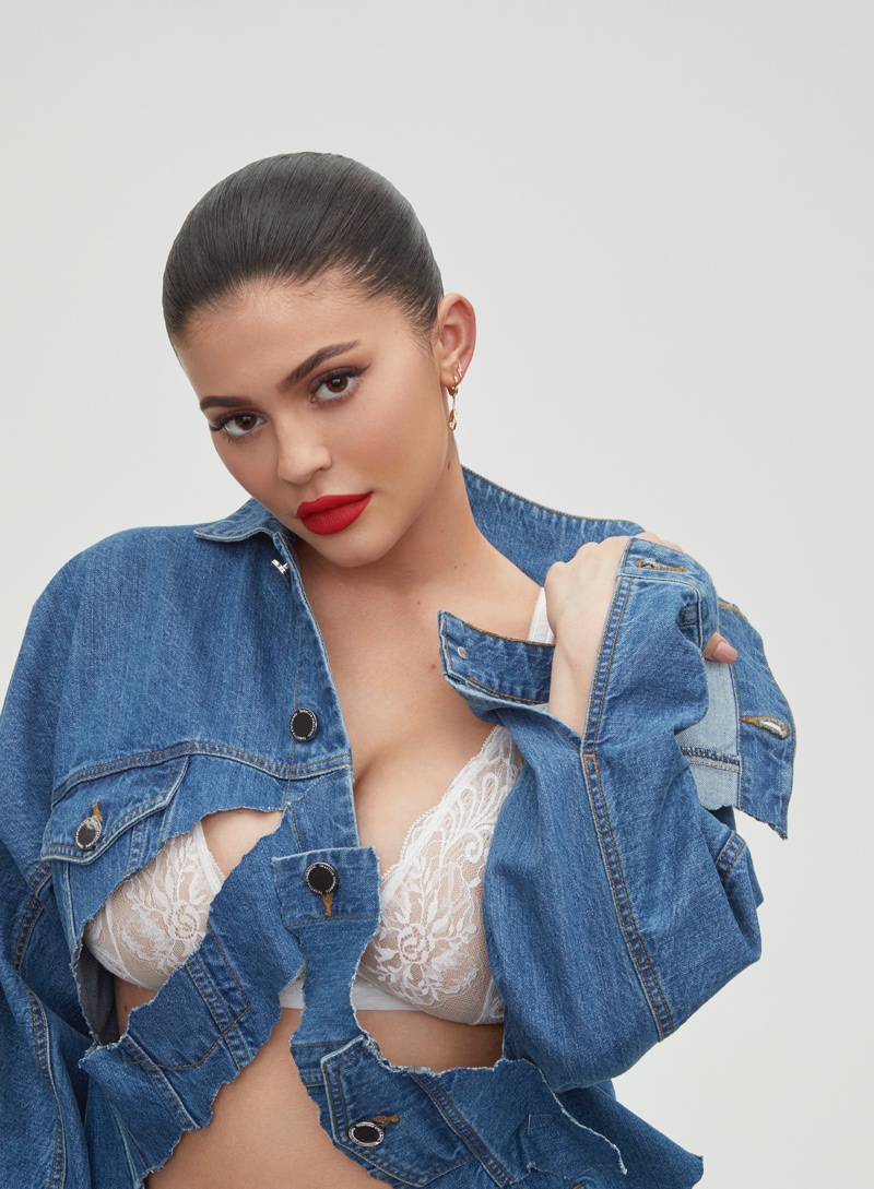 Showing off a red lip, Kylie Jenner wears denim jacket and lace bra